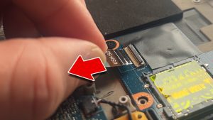 Unclip the locking tab and then disconnect the SD card reader cable.