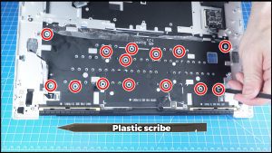 Use a plastic scribe to press through the holes and unmount the keyboard.